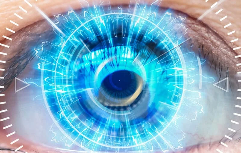 A close up of an eye with blue light coming from it.