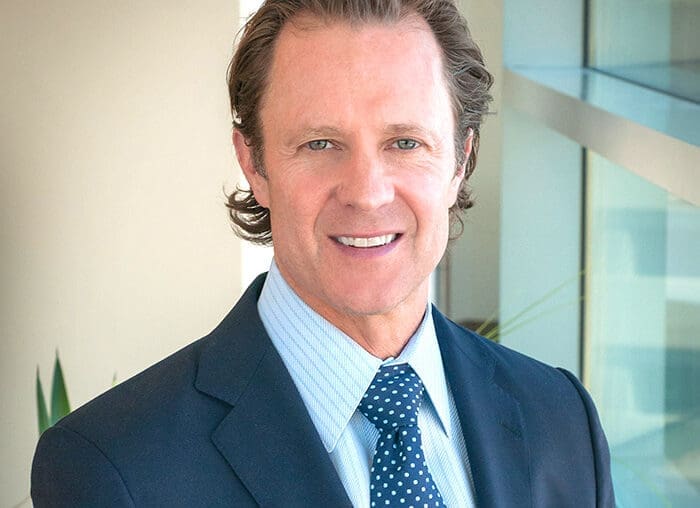 A man in suit and tie smiling for the camera.