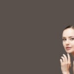 A woman with her hand up to her face.