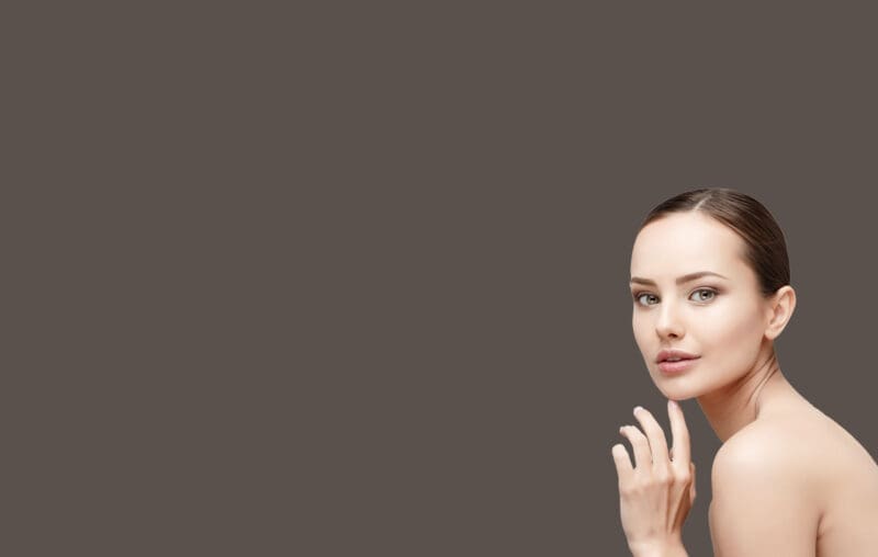 A woman with her hand up to her face.