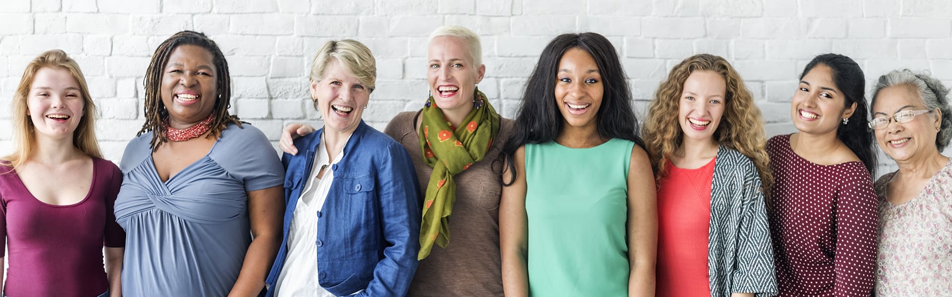 Three women standing next to each other smiling.