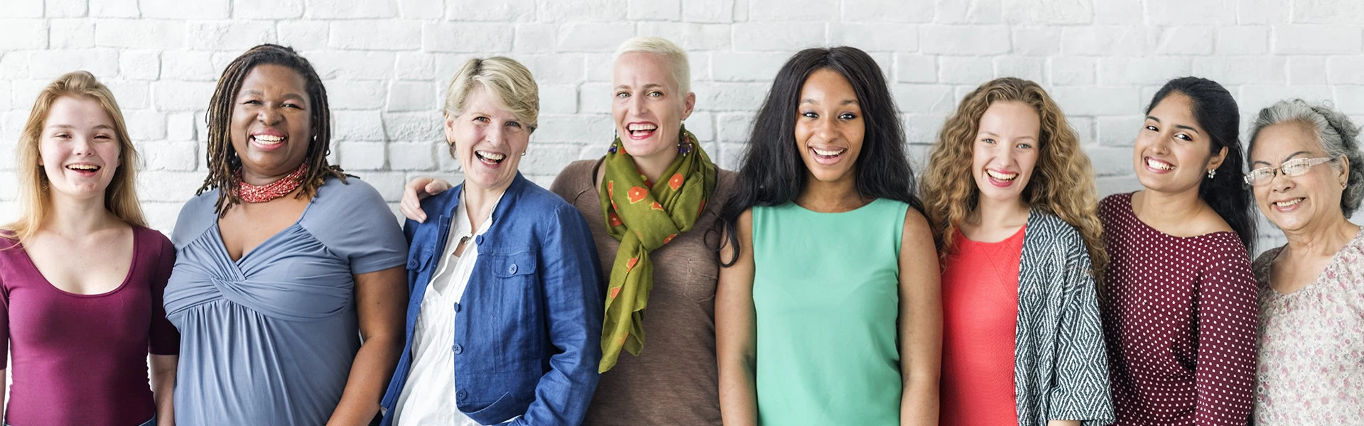 Three women standing next to each other smiling.